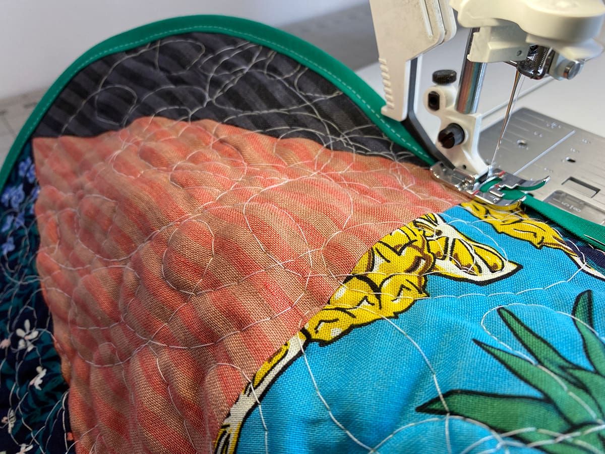 Sewing the bias binding onto the quilted jacket