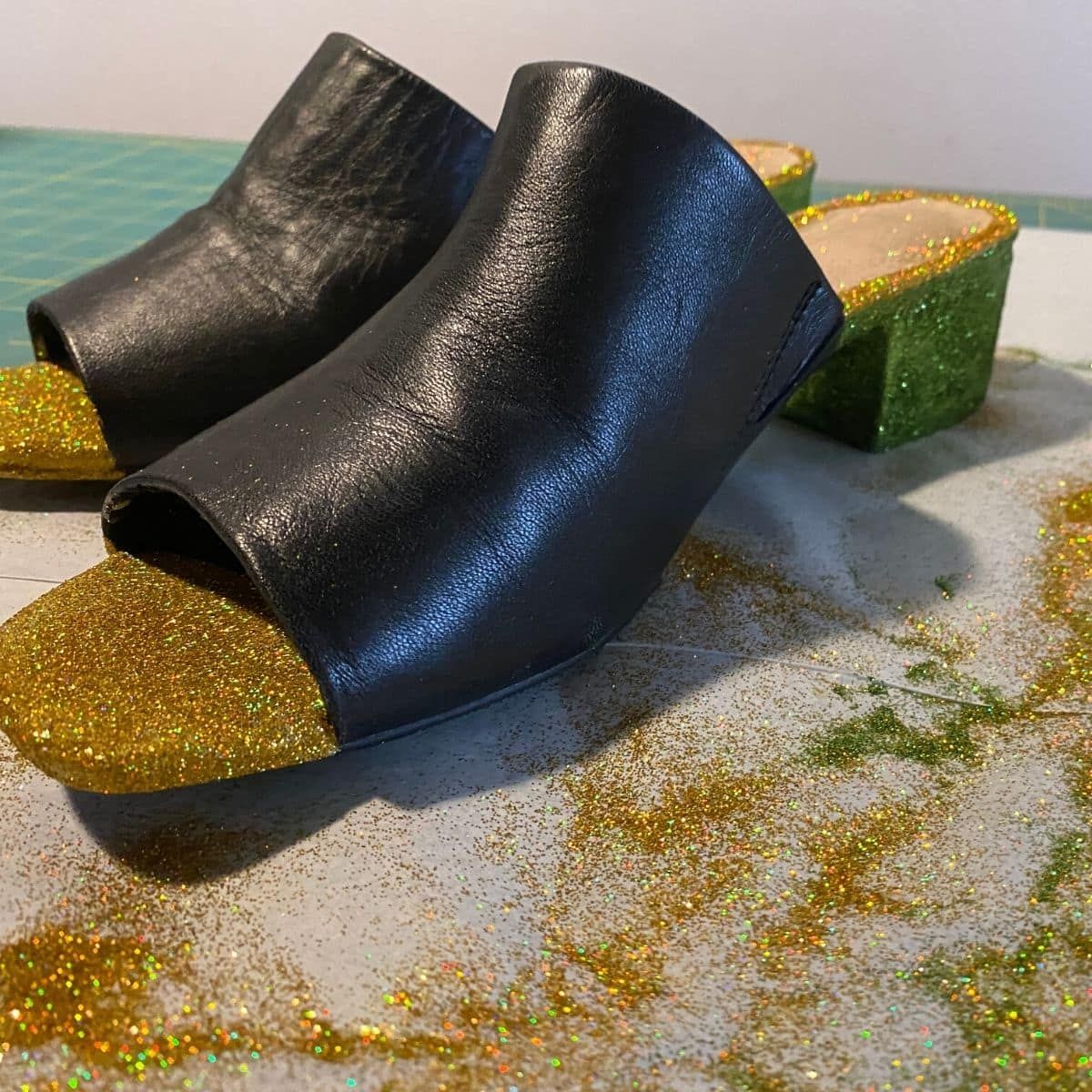 Black damaged shoes repaired with mod podge and glitter